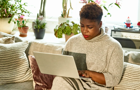 Woman entering information on laptop