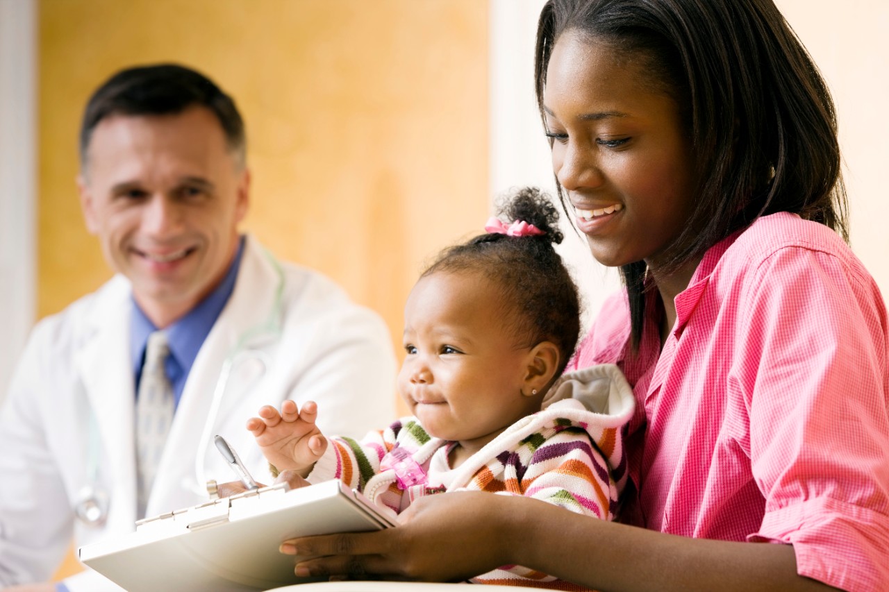 Mother and baby daughter filling out medical form