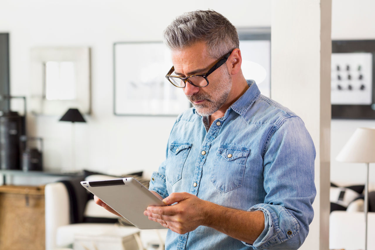 Gentleman using digital tablet in living room