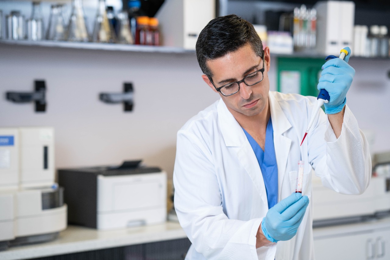 Laboratory technician inserting sample into test tube