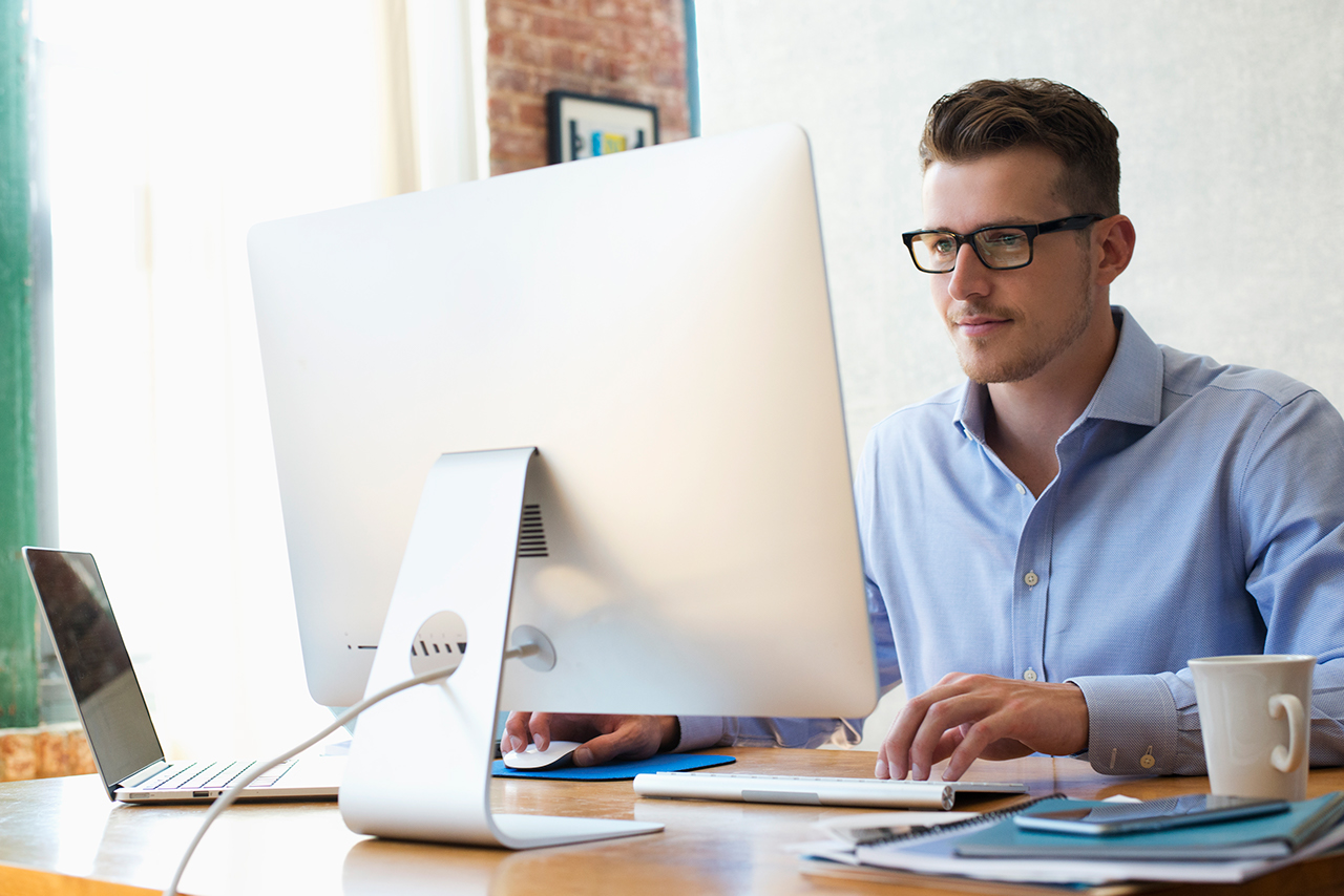 Caucasian businessman sitting at desk using laptop