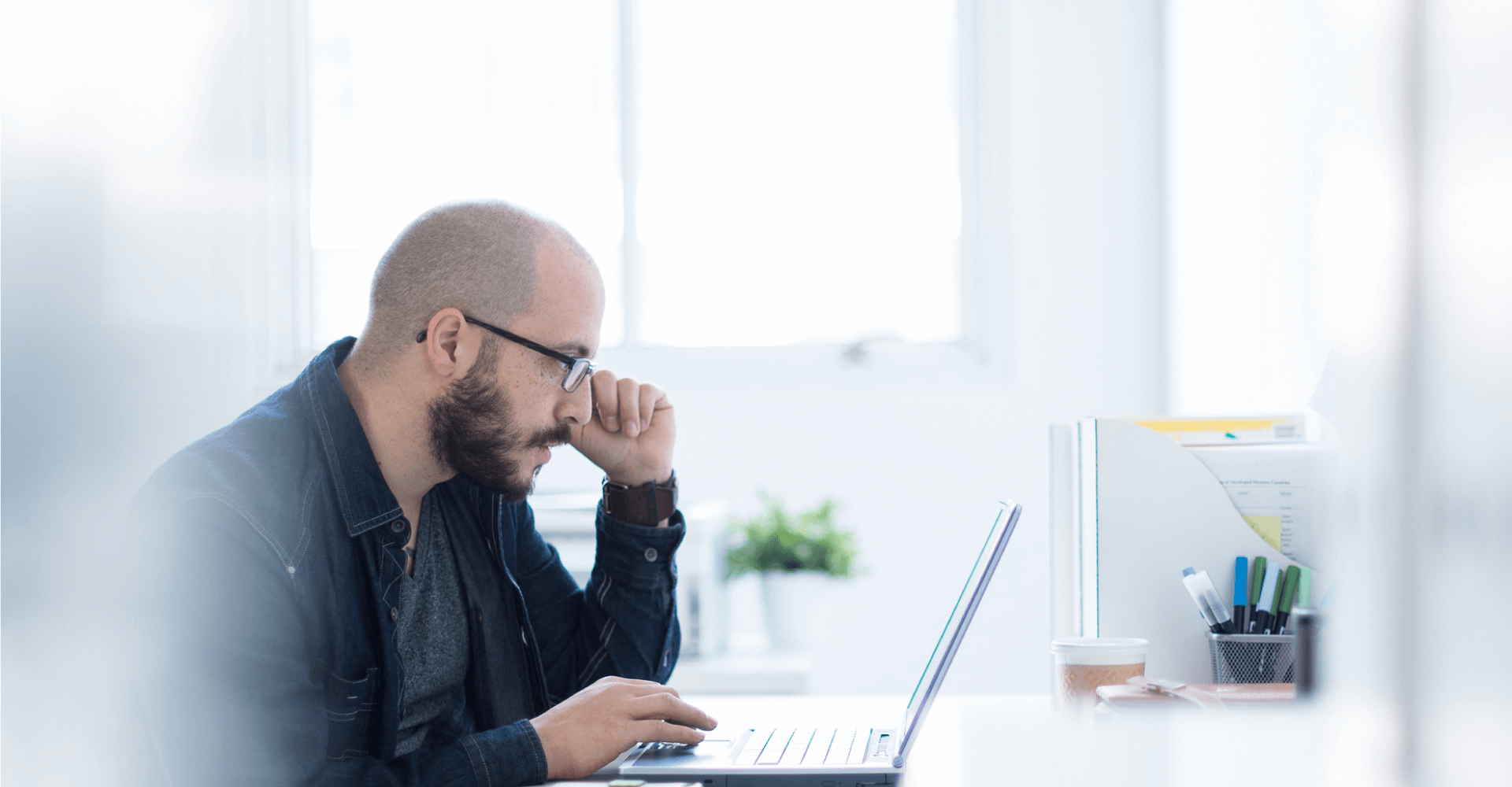 Man at desk looking at laptop computer